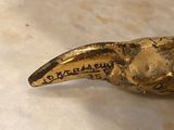 brass figurine of a bird on a marble counter top