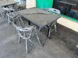 a table and chairs outside of a restaurant with a green door