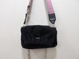 a black purse with a pink strap hanging on a wall