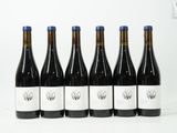 six bouteilles de vin sont alignées sur une surface blanche