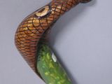 sculpture of a snake on a stick with a green body