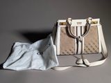 a white purse and a cloth bag on a table