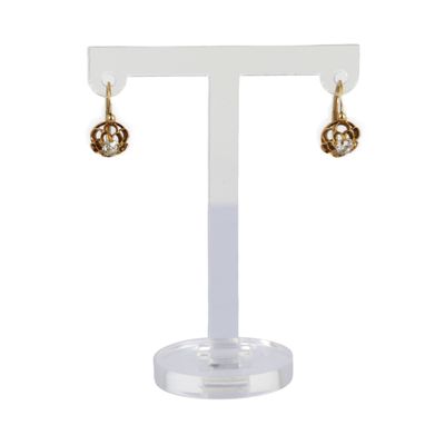 une paire de boucles d'oreilles posée sur un présentoir, sur fond blanc