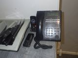 un téléphone noir posé sur un comptoir, à côté d'un autre téléphone