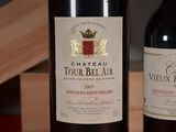 two bottles of wine sitting on a table next to each other