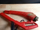 une photo d'une agrafeuse rouge posée sur une table en bois