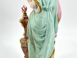 figurine of a woman in a blue dress holding a basket of flowers