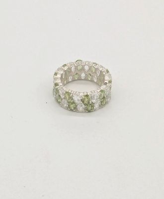 un gros plan d'une bague ornée de pierres vertes et blanches