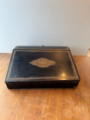 une petite boîte noire posée sur une table en bois