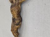 a wooden statue of jesus hanging on the wall