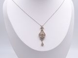 collier en métal argenté avec un pendentif en forme de poisson et un diamant