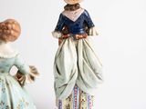 two figurines of a woman and a man standing next to each other