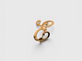 gros plan d'une bague en or sur une surface blanche