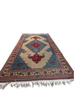 a blue and red rug with fringes on a white background