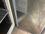 a silver refrigerator with a glass door in a kitchen