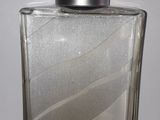 une image représentant un flacon de parfum posé sur une table