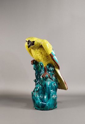figurine représentant un perroquet perché sur un rocher, sur fond gris