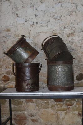 trois seaux posés sur une table devant un mur de briques