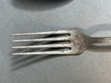 a fork and a spoon sitting on a table next to each other