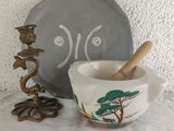 a bowl with a spoon in it next to a plate with a tree design