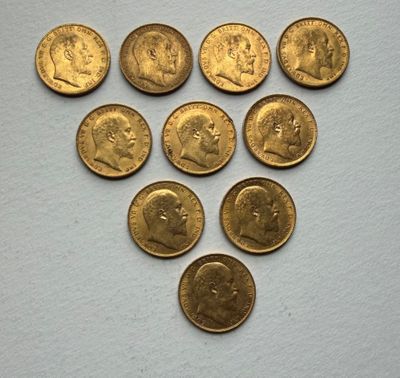 a close up of a bunch of gold coins on a white surface