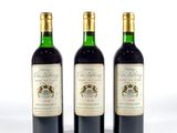 trois bouteilles de vin posées les unes à côté des autres sur une surface blanche