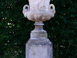 a large white urn sitting in the middle of the grass