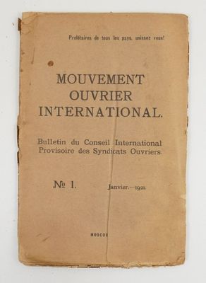 un vieux livre posé sur une table à côté d'un mur blanc