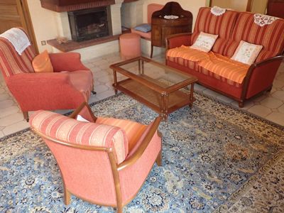 un salon avec un canapé, un fauteuil, une table basse et une cheminée