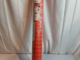 a roll of red plastic mesh on a white surface
