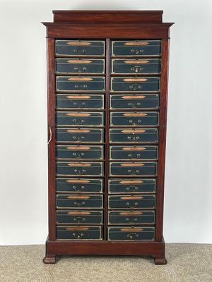 une vieille armoire en bois surmontée de nombreux tiroirs