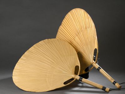 deux éventails en bois en forme de papillon posés sur une table