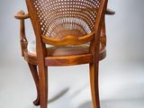 an image of a wooden chair with a woven back and arms