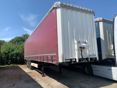 two semi trucks parked next to each other in a lot