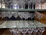 many wine glasses sitting on a shelf in a room