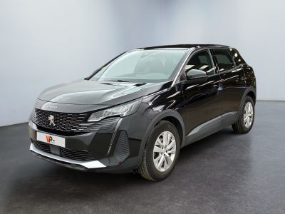 Une voiture noire est garée dans une pièce au sol noir.