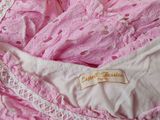 pink and white lace lingersuit with a label on it