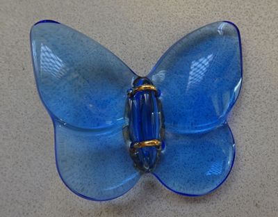 a blue glass butterfly sitting on a table