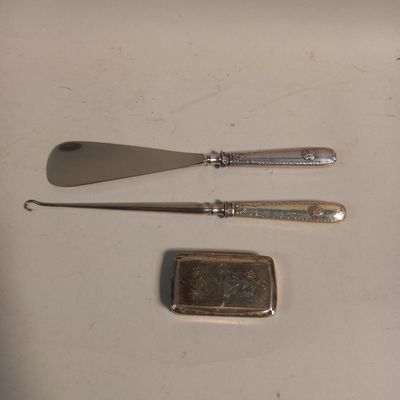 a spoon, knife, and card case sitting on a table