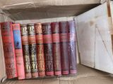 many books in a cardboard box on the floor