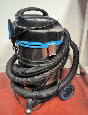 un aspirateur posé sur le sol à côté d'un mur