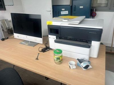 un ordinateur et une imprimante posés sur un bureau dans un bureau