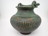 un vase vert posé sur une surface blanche