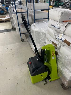 un cariste assis à côté d'une pile de matelas dans un entrepôt