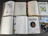several books are lined up on a table with drawings on them