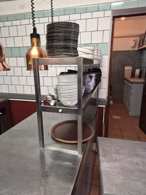 stainless steel counter top in a restaurant kitchen with plates stacked on it