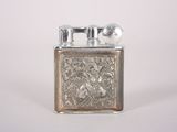 a silver lighter that is sitting on a white surface