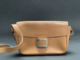 an image of a tan leather bag on a grey background