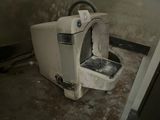 a dirty toilet in the corner of a room