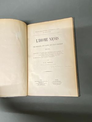 quelqu'un tient un livre ouvert sur une surface grise